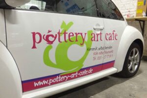 VW Beetle mit mehrfarbiger Folienbeschriftung für das Pottery Art Cafe