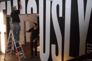 Detailansicht beim Anbringen von Folienbuchstaben auf Wand im Grey Office