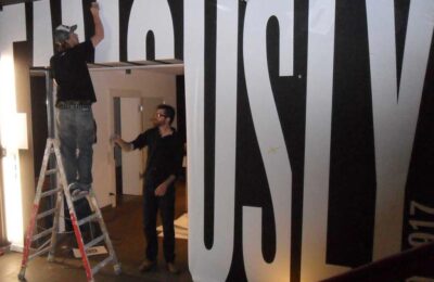 Detailansicht beim Anbringen von Folienbuchstaben auf Wand im Grey Office