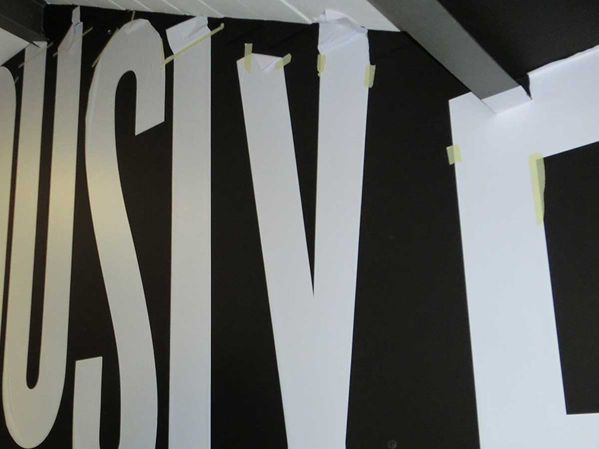 Folienbuchstaben lösen sich von der frisch gestrichenen Wand im Grey Office, Düsseldorf